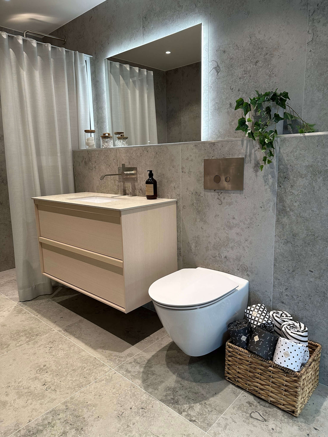 Lyxigt badrum med hotellkänsla, bambu toalettpapper i korg och elegant grå klinkergolv