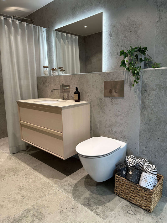 Lyxigt badrum med hotellkänsla, bambu toalettpapper i korg och elegant grå klinkergolv