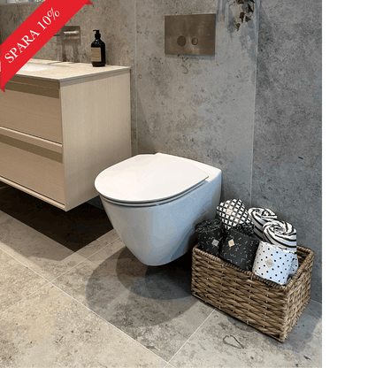 Bambu toalettpapper från Panboo Paper i korg i lyxigt badrum med grått klinker och mässingdetaljer